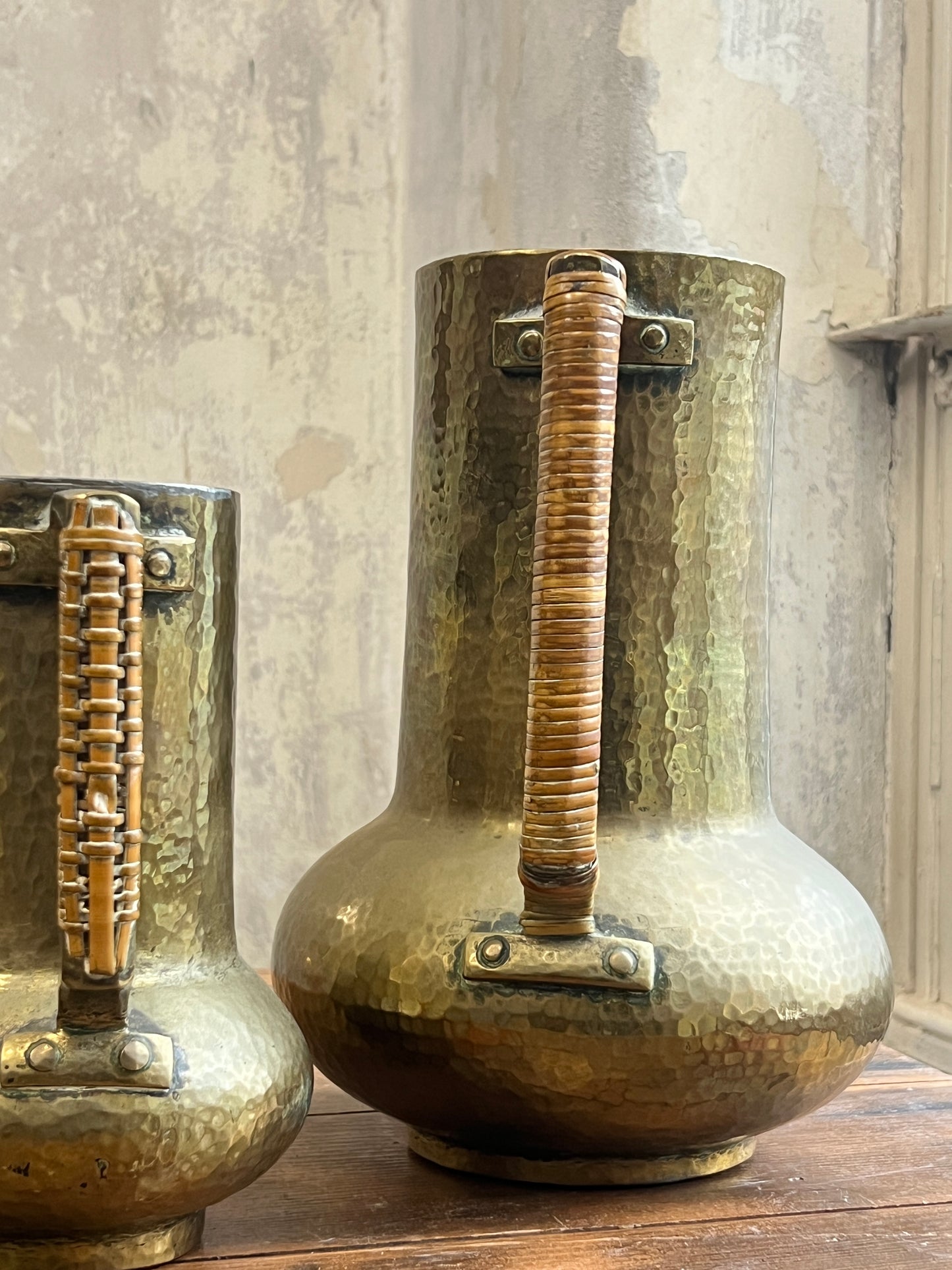 Two Graduating Arts and Crafts Brass Pitchers