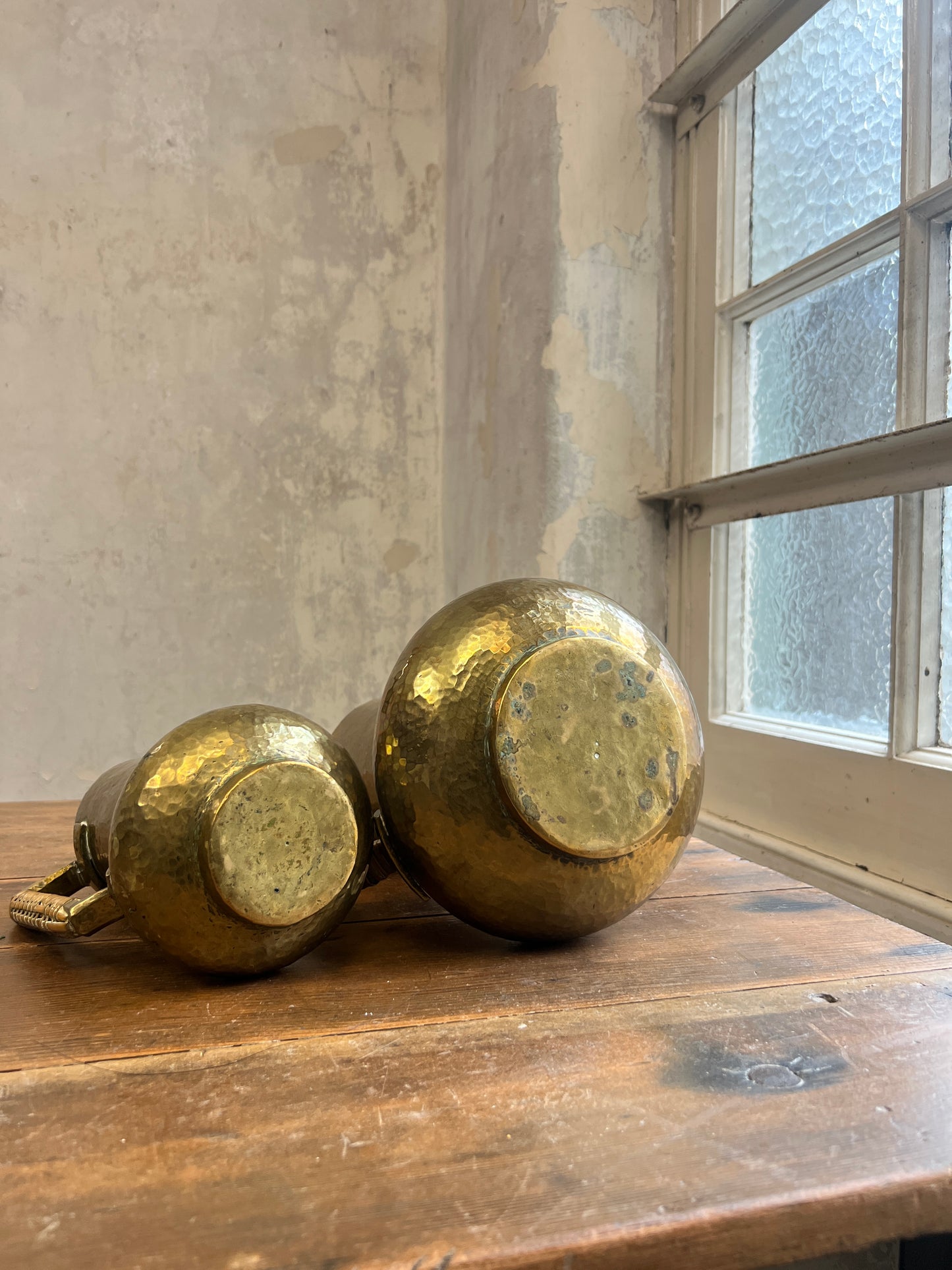 Two Graduating Arts and Crafts Brass Pitchers