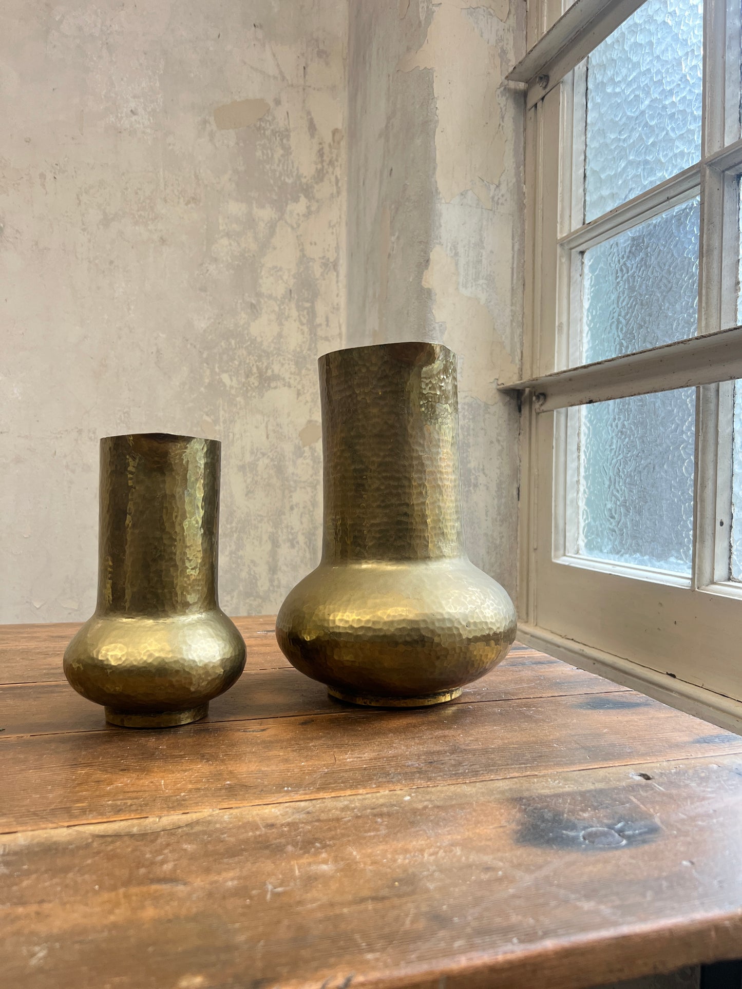Two Graduating Arts and Crafts Brass Pitchers