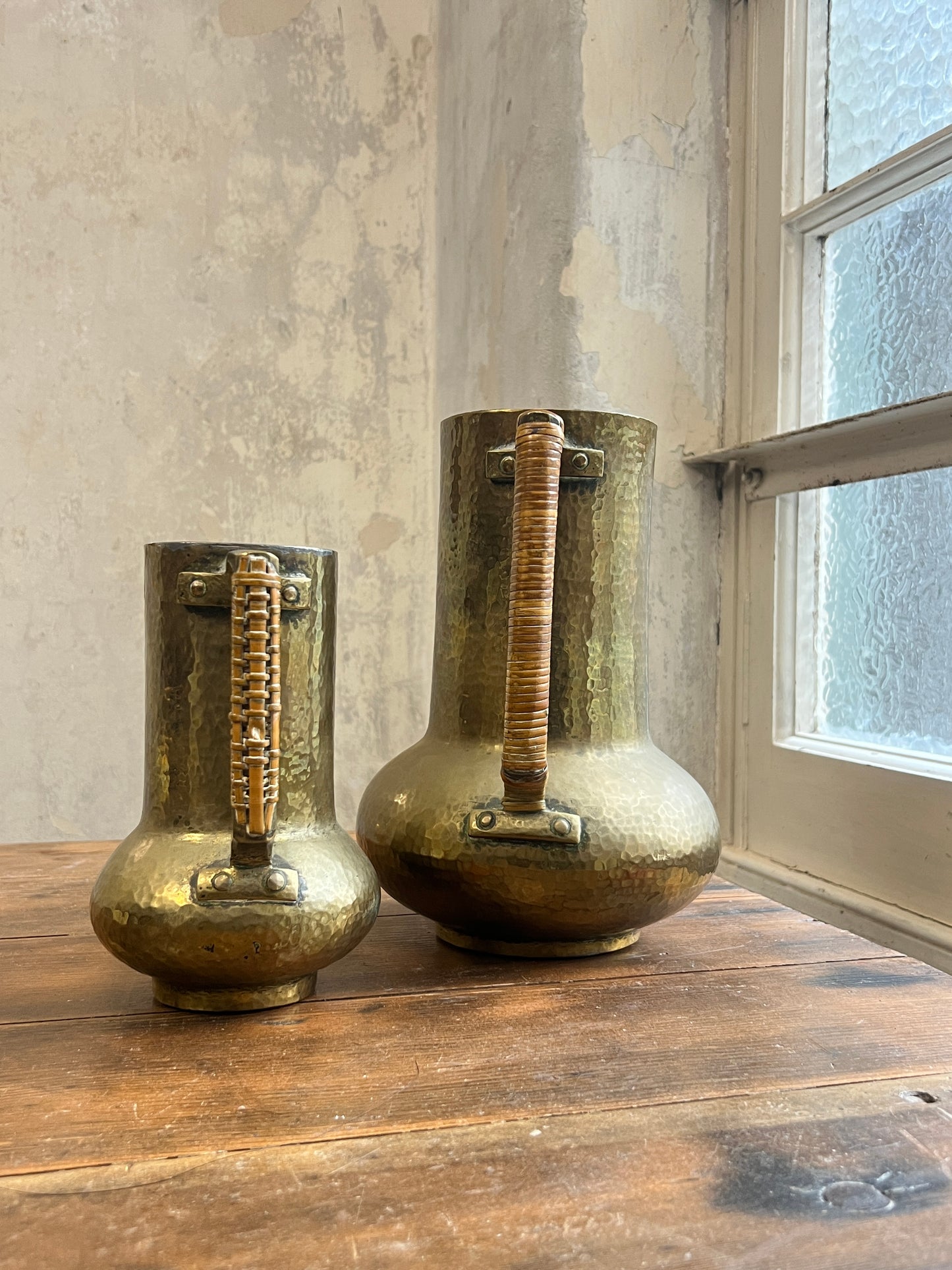 Two Graduating Arts and Crafts Brass Pitchers