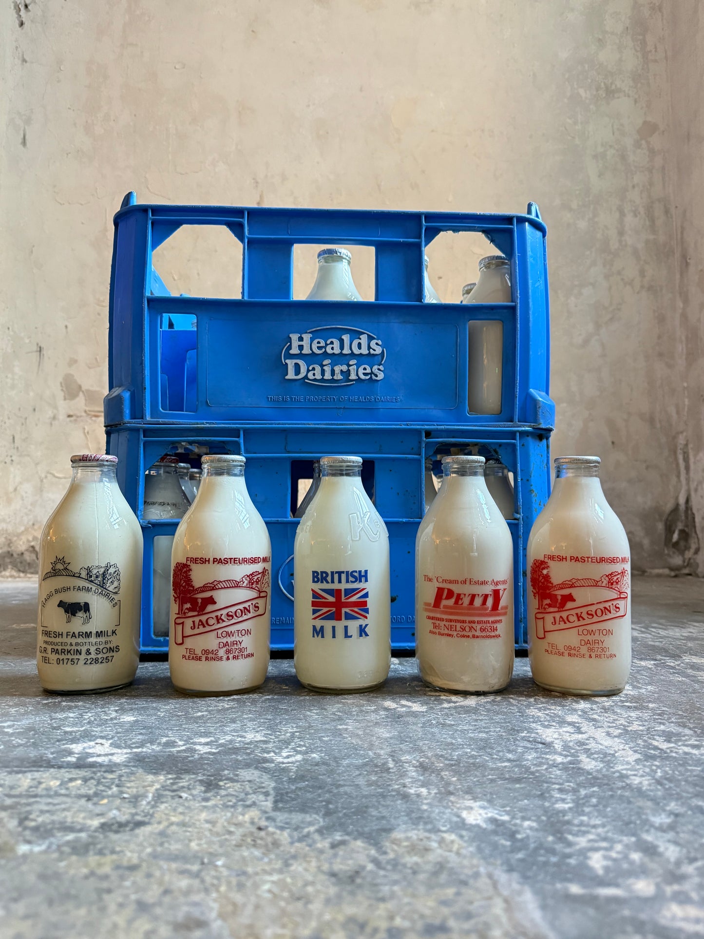 A Collection  of 37 Advertising Milk Bottles in Crates