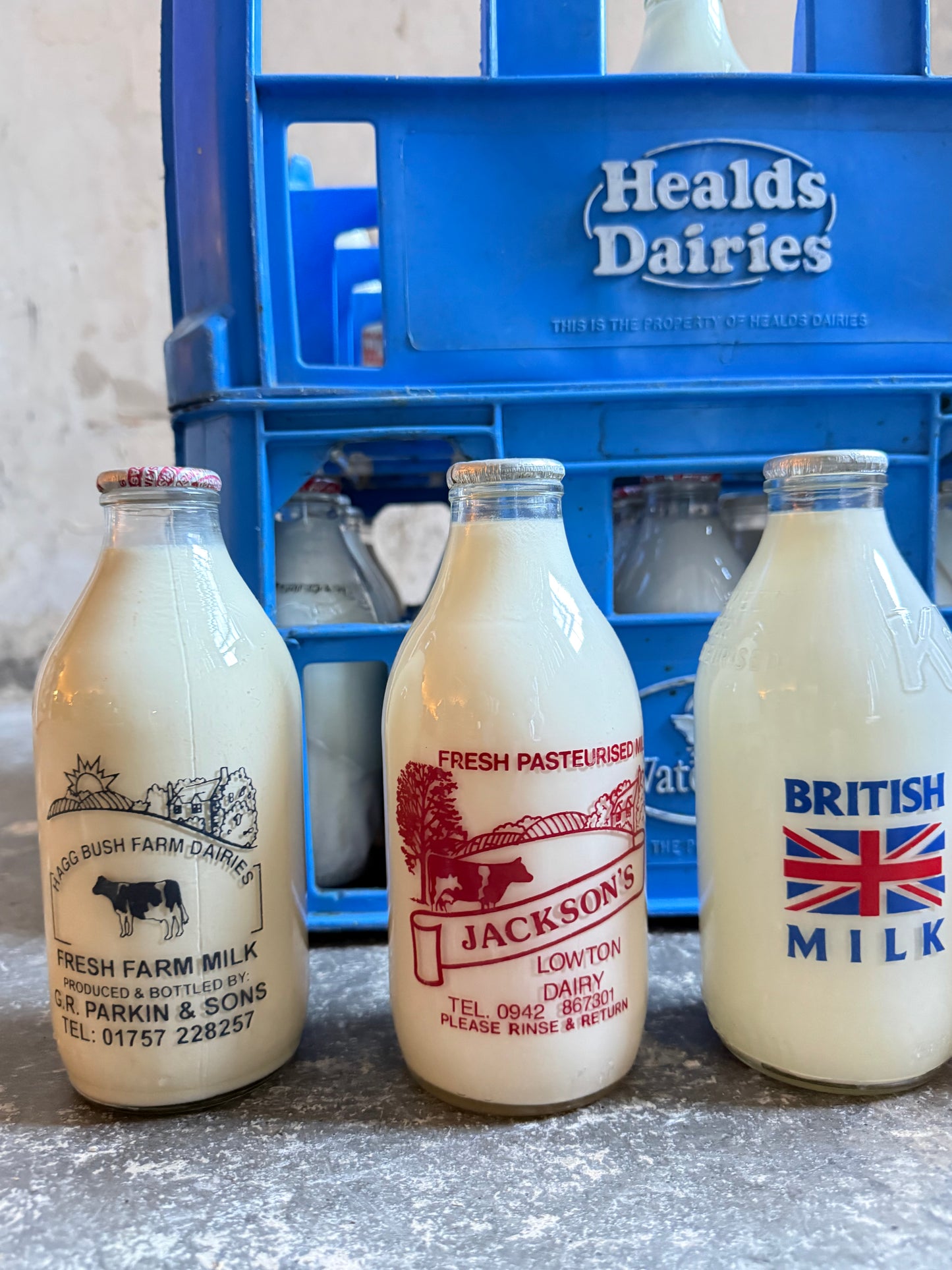 A Collection  of 37 Advertising Milk Bottles in Crates